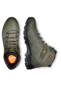 Bottes de randonnée en cuir vert avec des semelles en caoutchouc noir, présentant des œillets renforcés, des accents texturés et un intérieur rembourré avec un logo orange.