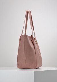Borsa tote in pelle rosa con una forma strutturata, due manici lunghi e una superficie liscia. Presenta un sottile accento metallico.