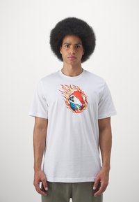 Tricou alb din bumbac, cu un grafic ce reprezentă o minge de baschet învăluită în flăcări, cu culori roșii, portocalii și albastre. Croială lejeră și mâneci scurte.