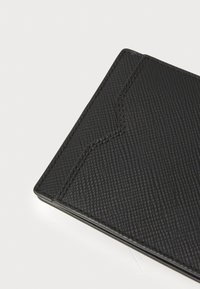 Portafoglio nero con texture, finitura liscia, caratterizzato da un design geometrico sulla superficie e cuciture a contrasto lungo i bordi.