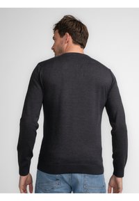 Pulover gri închis cu mâneci lungi și decolteu rotund, fabricat dintr-un material tricotat neted. Dispune de manșete și tiv cu model răsucit.