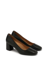 Scarpe con tacco alto in pelle nera, con punta arrotondata e tacco a blocco. L'interno presenta dettagli perforati su una soletta color nocciola.