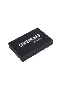 Boîte rectangulaire noire avec une finition mate, arborant du texte blanc en gras "COMMONLINES" et "par / BROTHERS" sur le dessus. Design simple sans images.