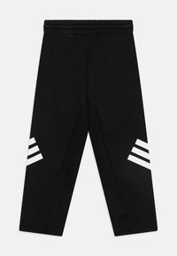 Melni sporta bikses ar elastīgu jostasvietu, kurām katrā pusē ir trīs baltas svītras. Izgatavotas no mīksta, teksturēta auduma.