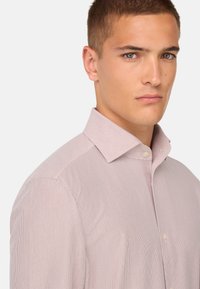 Camicia a righe rosso chiaro con colletto alla francese, chiusura a bottoni e tessuto dallo stile liscio. Presenta una silhouette aderente e un design classico.