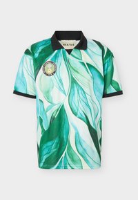 Κοντομάνικη ποδοσφαιρική φανέλα με πράσινο και μπλε σχέδιο φύλλων, μαύρο γιακά και τελείωμα μανικιών και στρογγυλό λογότυπο ομάδας στο στήθος.