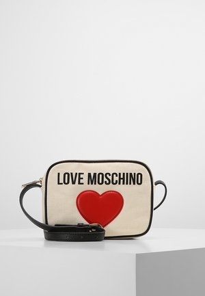 Sac bandoulière beige Love Moschino avec bordure noire, sangle noire réglable, logo noir en caractères gras et un grand cœur rouge sur le devant.