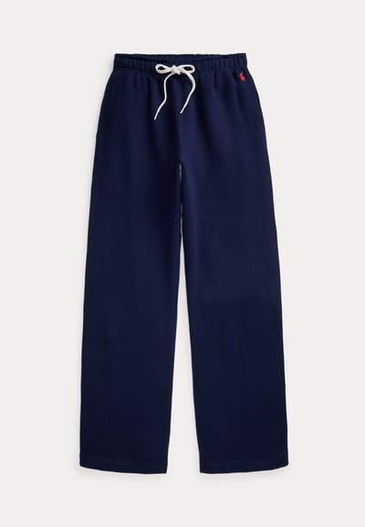 Donkerblauwe sweatpants met brede pijpen, elastische tailleband, wit trekkoord en klein rood geborduurd logo aan de rechterkant.