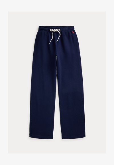 Donkerblauwe sweatpants met brede pijpen, elastische tailleband, wit trekkoord en klein rood geborduurd logo aan de rechterkant.