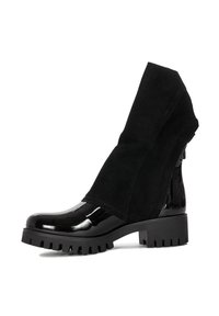 Czarne botki sięgające kostki, z połyskującym lakierowanym noskiem oraz miękką zamszową cholewką z charakterystycznym złożonym kołnierzem, teksturowaną gumową podeszwą.