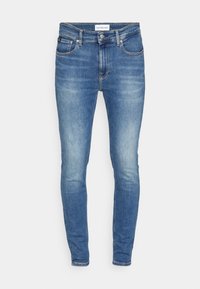 Blå denimjeans med slim fit. Har standard femfickorsdesign och lätt blekning på låren. Etikett synlig vid midjan.