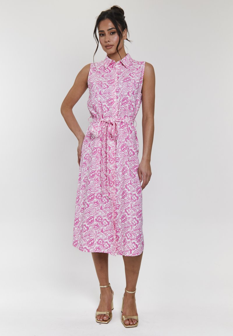 Abito senza maniche di colore rosa con motivi floreali, colletto, cintura in vita e orlo a metà lunghezza. I dettagli includono una silhouette fluida.