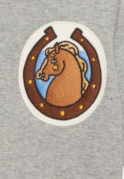 Sweatshirt cinza com um emblema bordado circular de uma cabeça de cavalo dentro de um ferradura castanha, com pontos amarelos e fundo azul.