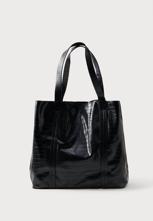 Sac fourre-tout noir à motif crocodile avec deux poignées, finition brillante, design spacieux et détails de couture verticale sur les côtés.