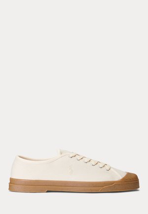 Canvas-sneakers i creme med et tekstureret design, gummifyldt tåhætte og tan-farvet ydersål. Har fem snørehuller og et logo på siden.