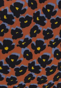 Tissu présentant un fond orange vif avec des fleurs noires bordées de bleu clair et des centres jaunes, créant un motif audacieux.