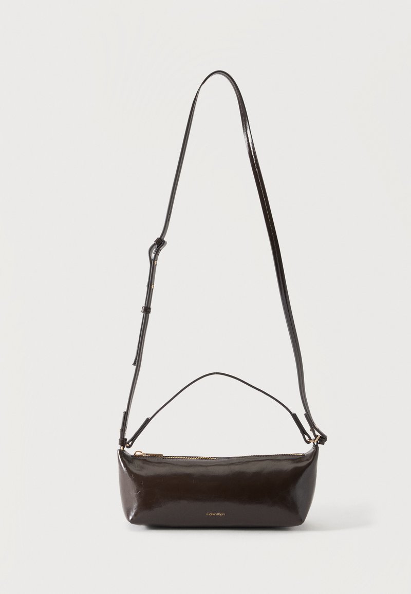 Petit sac à bandoulière en cuir marron foncé brillant avec bandoulière réglable, poignée supérieure et fermeture éclair dorée.