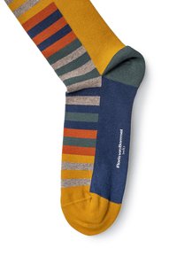 Stribede bomuldsstrømper med farverne gul, blå, orange, grøn og grå, med et logo ved anklen og en ribbet tekstur.