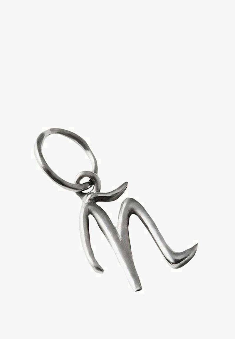 Colgante de plata con forma de la letra "M" estilizada y un lazo para sujeción. El diseño presenta líneas suaves y fluidas y un acabado pulido.