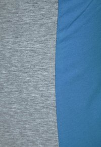 Tvåfärgad tyg med en melerad grå sektion och en solid blå sektion. Båda delarna har släta, mjuka texturer och är sannolikt bomullsblandningar.