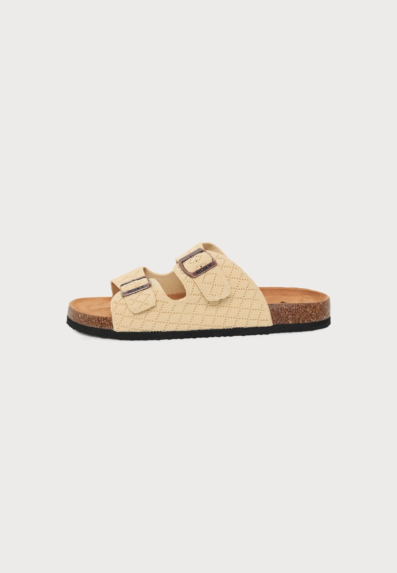 Sandale beige à bout ouvert avec deux brides réglables à boucle, dessus texturé, semelle intérieure en liège et semelle noire, vue de côté.