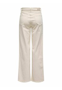 Pantalons larges crème en coton, dotés de deux poches arrière et de passants de ceinture, avec une coupe droite et une texture lisse.