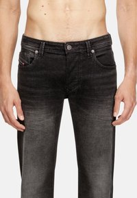 Črne jeans hlače iz denima z zbledelim videzom, zasnovo s petimi žepi, kovinsko zap closure in kontrastnimi šivi.