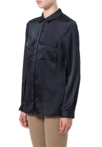 Námořnická modrá saténová košile na knoflíky s límečkem, dvěma náprsními kapsami, dlouhými rukávy a hladkým, lesklým povrchem.