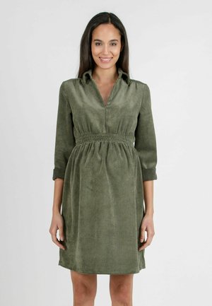 Robe en velours côtelé vert olive avec un col, taille élastique et manches trois-quarts. Présente une texture côtelée verticale.
