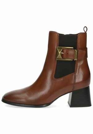 Brown leather ankle boot with a pointed toe, elastic side panels, and a gold buckle accent. Features a textured black block heel.