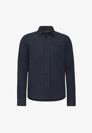 Nappapaita tummansinisestä puuvillakankaasta, jossa on kauluspääntie, kaksi rintataskua ja normaali mitoitus pitkillä hihoilla.