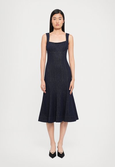 Robe en denim bleu foncé avec un décolleté carré, des bretelles larges, un corsage ajusté et une jupe évasée. Aucune motif ou ornement visible.