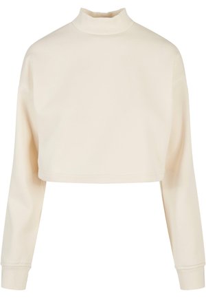 Cropped sweatshirt in cream, featuring long sleeves, a high neck, and a soft texture with ribbed accents at the neckline and cuffs.