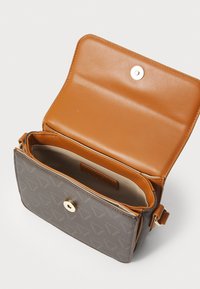 Καφέ δερμάτινη τσάντα χιαστί με υφή, με χρυσές λεπτομέρειες, που διαθέτει μαγνητική κλείσιμο και εσωτερικό σε αντίθετο καφέ χρώμα.