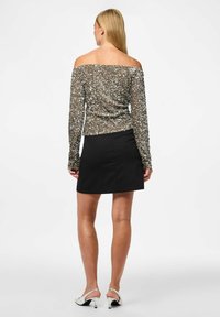 Zelta un sudraba toņos, off-the-shoulder sek un topi, apvienota ar melnu mini svārku. Ar garām piedurknēm un ciešu piegriezumu.