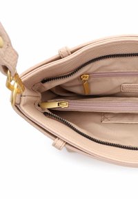 Hele roosa nahast käekoti sisemus, millel on kaks lukuga taskut, kuldsed detailid ja pehme kangast vooder tekstuurse viimistlusega.