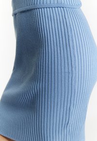 Gonna in maglia a coste di colore azzurro chiaro. Presenta un design aderente con una texture liscia e una vita elasticizzata, evidenziando strisce verticali.