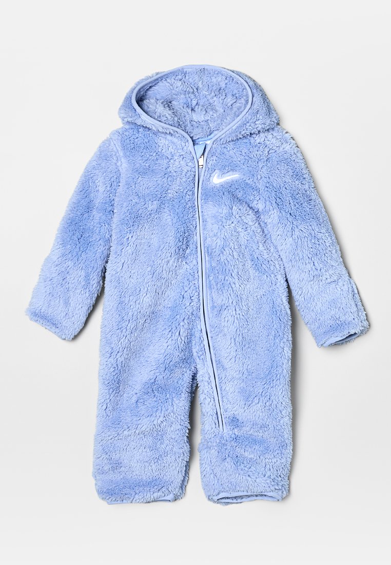 Mono de una pieza de color azul claro, peludo, con capucha, cierre de cremallera completo y puños elásticos. Presenta un destacado logotipo blanco de Nike en el pecho.