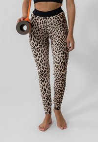 Lepardtrykte tights laget av elastisk stoff; tettsittende design med svart midjebånd, ankelmansjetter og glatt tekstur. Matte inkludert.