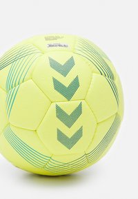 Pallone da calcio giallo con accenti blu, caratterizzato da un design esagonale, superficie testurizzata e motivi a chevron. Include marchi e etichette.