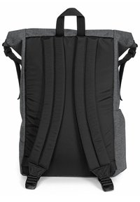 Zaino in tessuto grigio con spallacci neri imbottiti, dotato di una maniglia centrale sulla parte superiore e schienale sagomato per comfort e supporto.