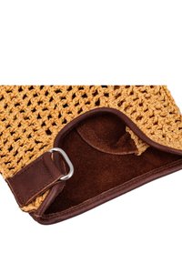 Braune Wildleder- und geflochtene Strohtasche mit einem strukturierten, offenen Strickdesign, einem Tragegurt und Metallringakzent.