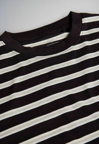Black and white striped crew neck t-shirt with visible stitching and "Made in Bangladesh" label inside collar.