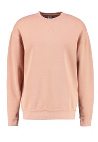 Sudadera rosa clara con cuello redondo y mangas largas. Presenta puños acanalados y un dobladillo sin rematar para añadir textura y detalle de diseño.
