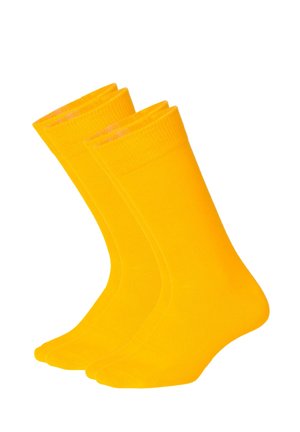 Twee paar felgele crew sokken, rechtopstaand, afgebeeld tegen een witte achtergrond.