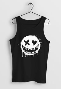 Black tank top featuring a large white graphic of a smiley face with exaggerated teeth, crossed eyes, and heart-shaped pupil, with dripping paint detail.
