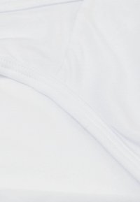 Vitt stretchtyg med slät yta och lätt lyster. Kanterna har fina sömmar, vilket ger ett rent och sömlöst utseende.