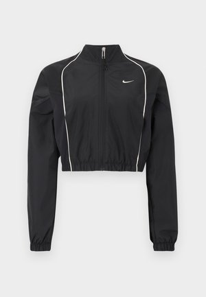 Czarna krótka kurtka z lekkiego materiału, wyposażona w pełny zamek, wysoki kołnierz, elastyczne mankiety i białe ozdobne przeszycia wzdłuż szwów.