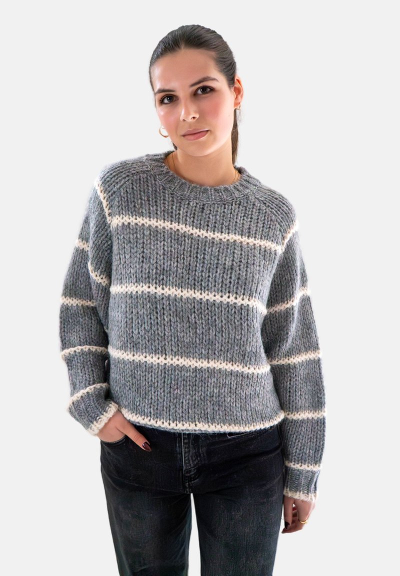Grijze gebreide trui met witte horizontale strepen, voorzien van een ronde halslijn en lange mouwen, gecombineerd met donkere jeans. Gezellige textuur en losse pasvorm.