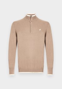 Pull beige avec un col demi-fermeture éclair, des poignets côtelés et un accent crème au niveau du col et de l'ourlet. Présente un petit logo sur le côté gauche de la poitrine.